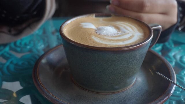 Man enjoys coffee in a cafe with decorative blue table at afternoon