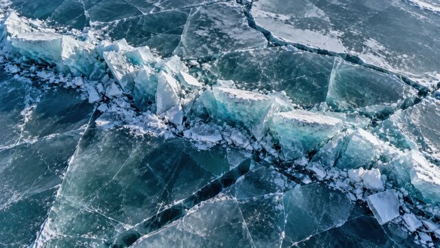 Pressure ridge in frozen lake ice, uplifted translucent slabs, turquoise fracture line and aerial geometry. Winter texture background for design. For climate media and seasonal publishing.