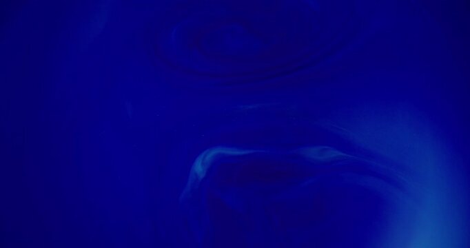 Blur ink flow. Acrylic water pigment. Vibrant blue navy color splash liquid texture bright shiny fluid spreading on abstract background.