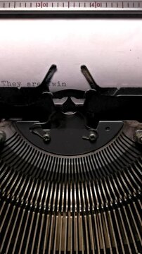Vertical Macro Shot of Vintage Typewriter Typing the Words They Are Twins