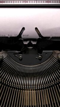 Vertical Macro Shot of Vintage Typewriter Typing the Words Welcome to the World