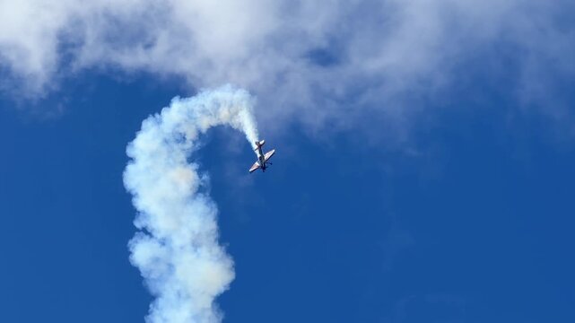 Aerobatic Stunt Plane Performing Vertical Dive with Smoke Trail