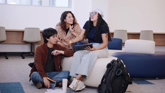 Latin university students celebrate successful teamwork with a high five while laughing together during a campus study session