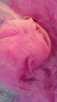 Vertical video. Shimmer vapor. Glitter cloud splash. Defocused pink white color ink sparkling water broken glass texture on abstract dark black bokeh art background.