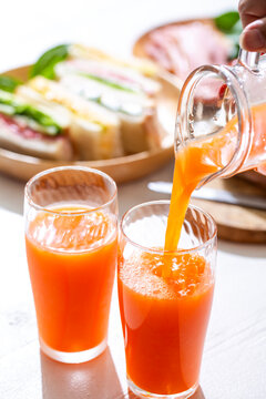 野菜ジュースを注ぐ　健康的な朝の食卓