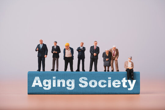 Aging society concept with miniature people and seniors for population aging, demographic change, elderly workforce, financial retirement challenges, healthcare needs and social welfare planning.