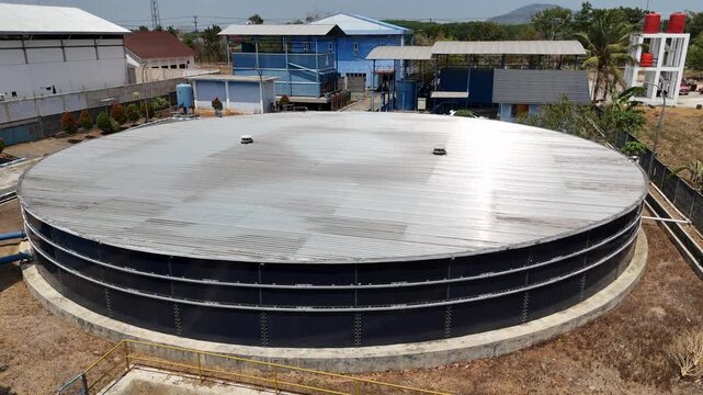 Large circular water storage tank located within an industrial site in South Kalimantan Indonesia