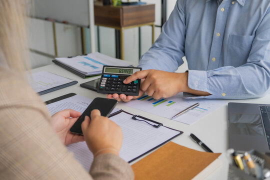 Asian businessman showing number on calculator