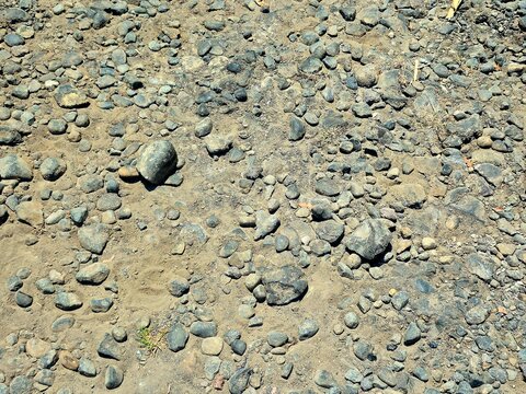 Natural texture of small pebbles and stones on sandy ground
