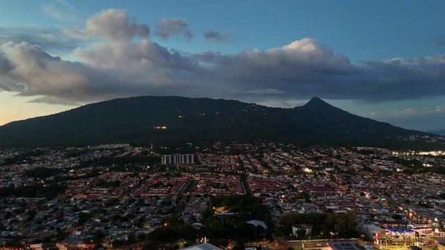 Vista panor&aacute;mica del volc&aacute;n de San Salvador con un cielo azul y nubes sobre el cono rodeado de la ciudad de Santa Tecla en El Salvador formato horizontal