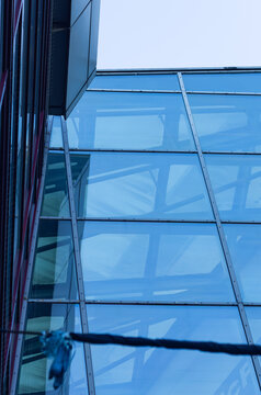 Close up view of the modern glass facade of the Batory Shopping Center located in the city center of Gdynia, Poland. The architectural details feature reflective blue glass panels and steel frames.