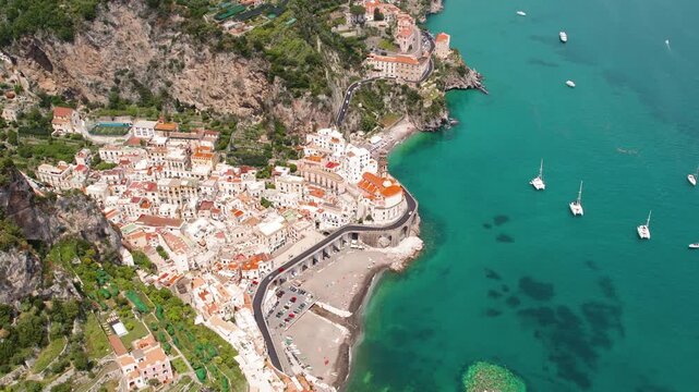 Aerial view of Atrani city and comune on Amalfi Coast in the province of Salerno in Italy. Beach, buildings, and sea with boats.