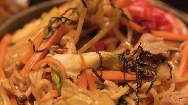 Stirring Japanese Yakisoba Noodles in Skillet with Chopsticks
