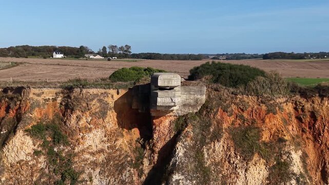 HKB Heuqueville fire post bunker built into Normandy coastal embankment, surrounded by agricultural land and vegetation in France
