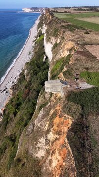 Normandy coastline steep chalk cliffs, a World War II bunker, beach, sea and surrounding agricultural fields