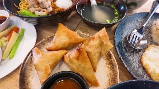 Top Down View of Crispy Fried Samosas and Asian Dishes on Table