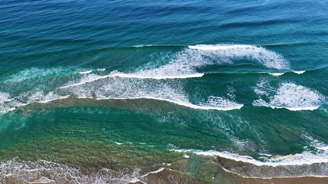 Aerial View of Turquoise Ocean Waves Breaking on Coast