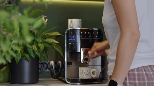 Woman making coffee with coffee machine at home coffee station