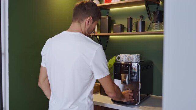 Man turning on lights in home coffee corner before making coffee