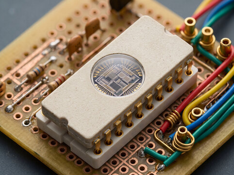 Ceramic eprom chip with transparent window on prototyping board for firmware development.