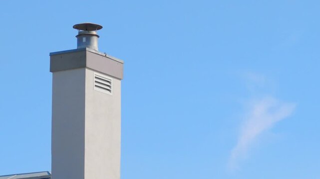 Modern Chimney with Metal Cap Against Clear Blue Sky with Copy Space