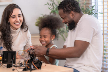 Fototapeta premium A close family of three explore a blue robotic arm together by a window with green plants, celebrating learning together with a clean modern aesthetic perfect for family and lifestyle.