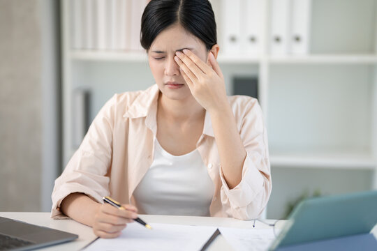 Eye problems, Asian women use hand cover eyes due to eye irritation, eye rubbing, dry, eye pain after look laptop long time, migraine, headache, blurred vision, photophobia, small words