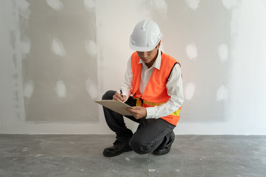 inspector or engineer is inspecting construction and quality assurance new house using a checklist. Engineers or architects or contactor work to build the house before handing it over to the homeowner