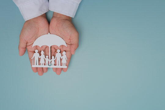 Hand holding paper umbrella provides family insurance protection and safety ensuring peaceful care with confident peace of mind