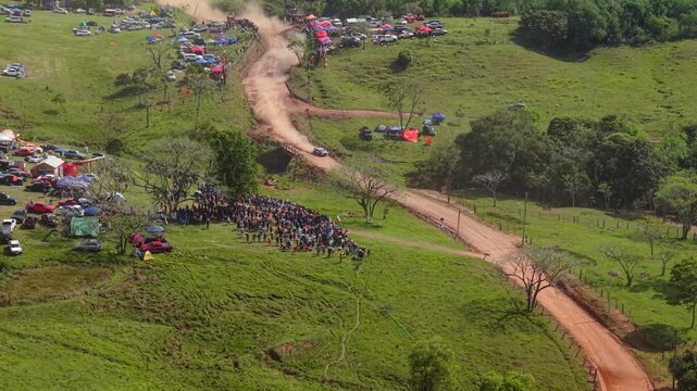 Aerial View of Fast Rally Car Racing on Dusty Dirt Road at Nueva Alborada Paraguay Rally Event