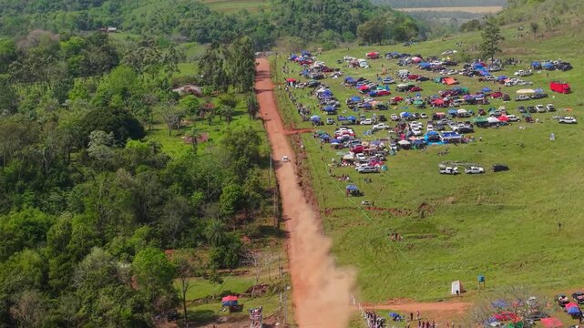 Aerial View of Rally Car Driving on Red Dirt Track with Crowds at Nueva Alborada Paraguay Event
