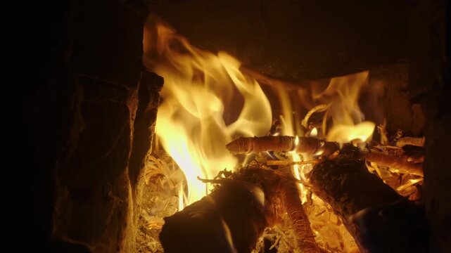 Burning firewood coals traditional clay, bright red flames glowing embers at outdoor, keep warm, smoke, long tongues of flame of burning fire in rural setting rustic outdoor brick stove in in darkness