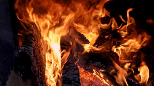 Burning firewood and coals traditional clay, bright red flames and glowing embers at outdoor, keep warm, smoke, long tongues of flame of burning fire in rural setting rustic outdoor brick stove.