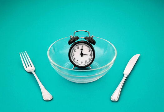Clock Inside Bowl With Fork And Knife On Table Setting