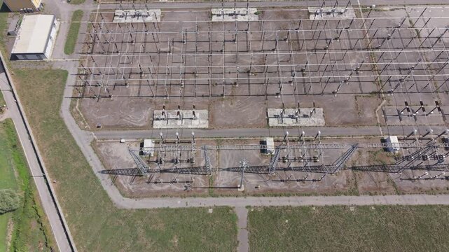 Aerial view of an industrial electricity facility in Settimo Milanese, with high-voltage grid equipment and supporting structures.