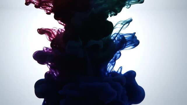 Multicolor ink clouds diffusing in clear water against white background in slow motion