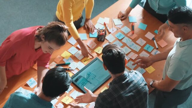 Aerial view of developer team discussing and showing digital program and writing by using Ux Ui design. Top down view of business people develop wireframe prototype for phone and computer. Symposium.