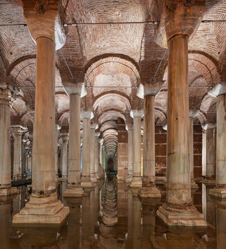 Interior view of the ancient Basilica Cistern featuring iconic marble columns and vaulted brick ceilings with water reflections in Istanbul, Turkey