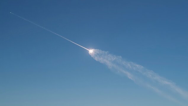 White Airplane Flying High Through a Clear Blue Sky, Leaving a Dramatic Contrail Above Bright Clouds During Rapid Air Travel