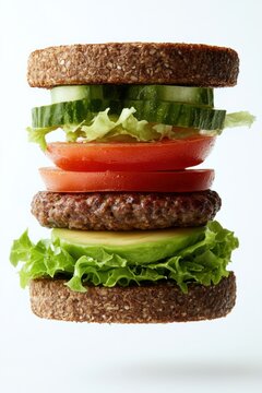 floating veggie burger with lettuce, tomato, avocado, and vegan patty, isolated on white background