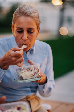 Businesswoman eating healthy salad lunch outdoors