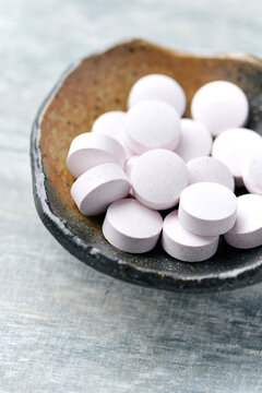 Creatine tablets on wooden background. Soft focus. Close up. Copy space.