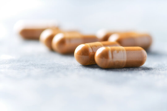 Tribulus terrestris extract. Dietary Supplement. Wooden  background. Soft focus. Close up. Copy space.