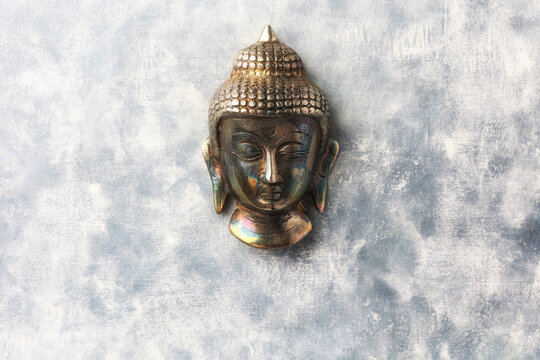 Buddha head on rustic wooden background. Soft focus. Top view. Copy space.