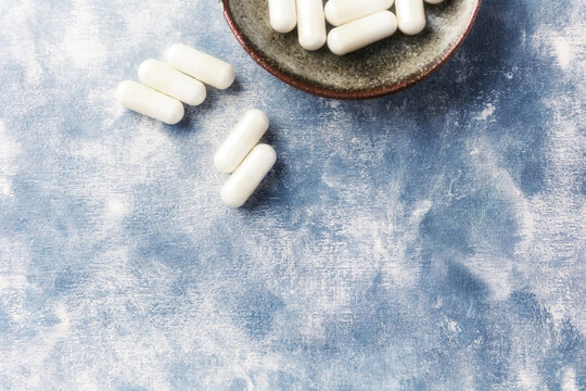 Creatine capsules on wooden background. Soft focus.  Top view. Close up. Copy space