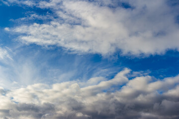 Fototapeta premium Fluffy white clouds drifting across a vibrant azure sky create a dreamy and peaceful atmosphere, capturing the essence of a bright sunny day filled with endless summer vibes