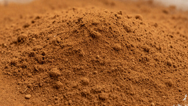Cinnamon powder texture background with reddish brown particles and soft dusty matte surface