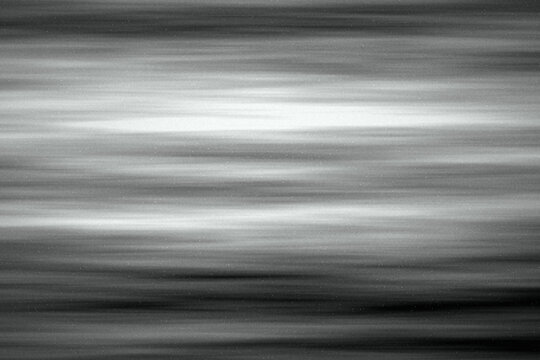 Horizontal speed blur motion noise texture background in black and white grayscale for modern futuristic graphic design.