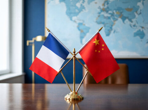France and China desk flags, international diplomacy and business partnership, office setting with world map background
