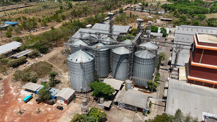 Aerial view of an industrial grain storage facility with metal silos and warehouses © Salsabila Ariadina